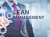 Lean Management Schriftzug vor männlichen Torso mit Anzug und roter Krawatte