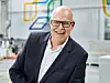 CEO Rainer Hundsdörfer, der Anzug und Brille trägt.