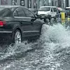 Auto passiert überflutete Straße