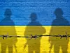Flagge der Ukraine, gemalt auf einer Backsteinmauer mit Soldatenschatten.