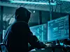 Hacker in Hoodie vor Bildschirmen