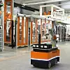 Ein Kuka Roboter fährt autonom durch eine Lagerhalle