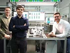 Entwickler Philipp Titze-Wolter, Student Moritz Baron und Technologiemanager Michael Hieb (von links) zeigen eine KI-basierte Prüfzelle, die in der Kabelfertigung von Phoenix Contact im Einsatz ist. Dort ermöglicht die automatisierte Qualitätskontrolle ein standardisiertes Qualitätsmanagement über verschiedene Standorte hinweg und entlastet die Mitarbeitenden in der Produktion von der manuellen Kontrolle jedes einzelnen Produkts.