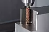 Nahaufnahme eines Fräsers von Pferd Tools beim Bearbeiten eines Metallblocks in einer Maschine.