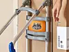 Rollator vor einer Tür, daneben eine Hand mit weißem Beutel und Barcode.