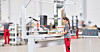 Mitarbeiterin an einer modernen Produktionsmaschine in einer hellen Industriehalle.